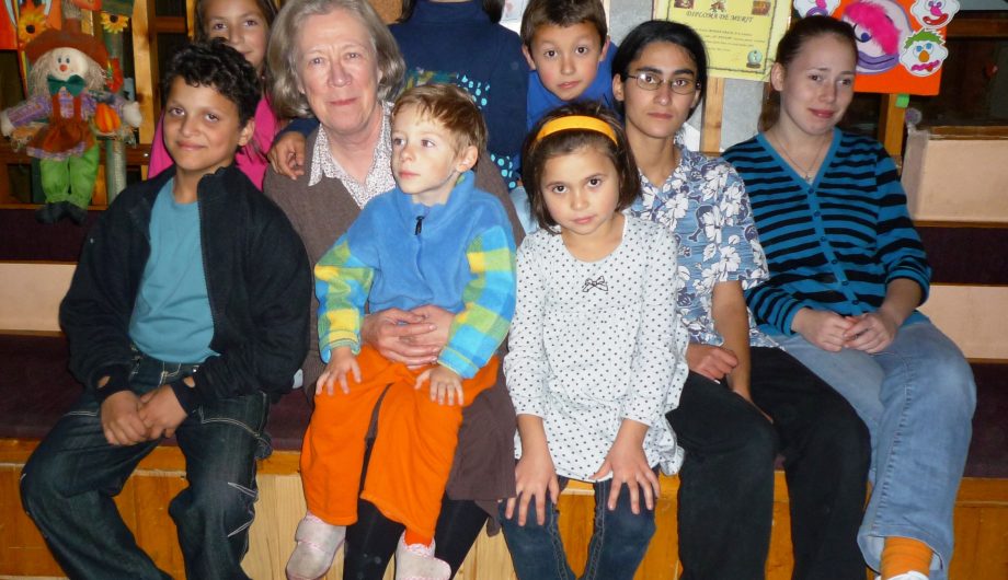 Jane Nicholson, Founder of FARA Charity sits with children of the FARA Foundation in Romania