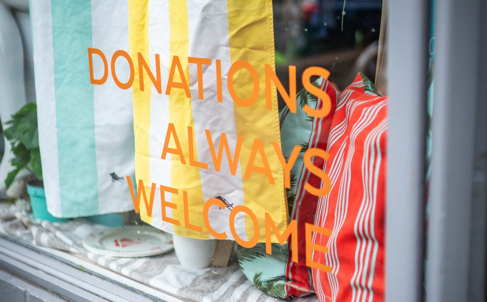 window display with text decal saying 'Donations Always Welcome'