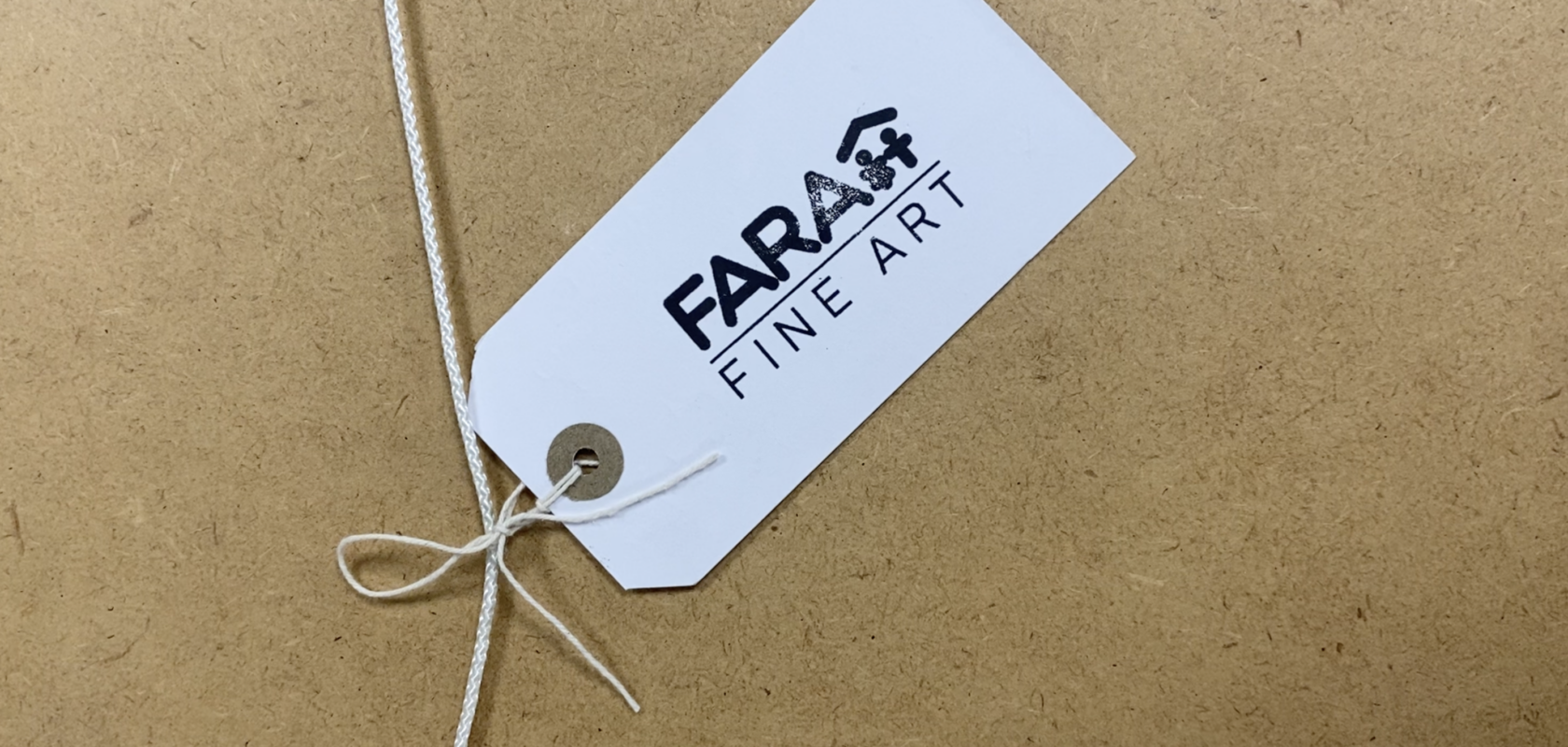A luggage tag stamped with the words "FARA Fine are" resting on a brown background